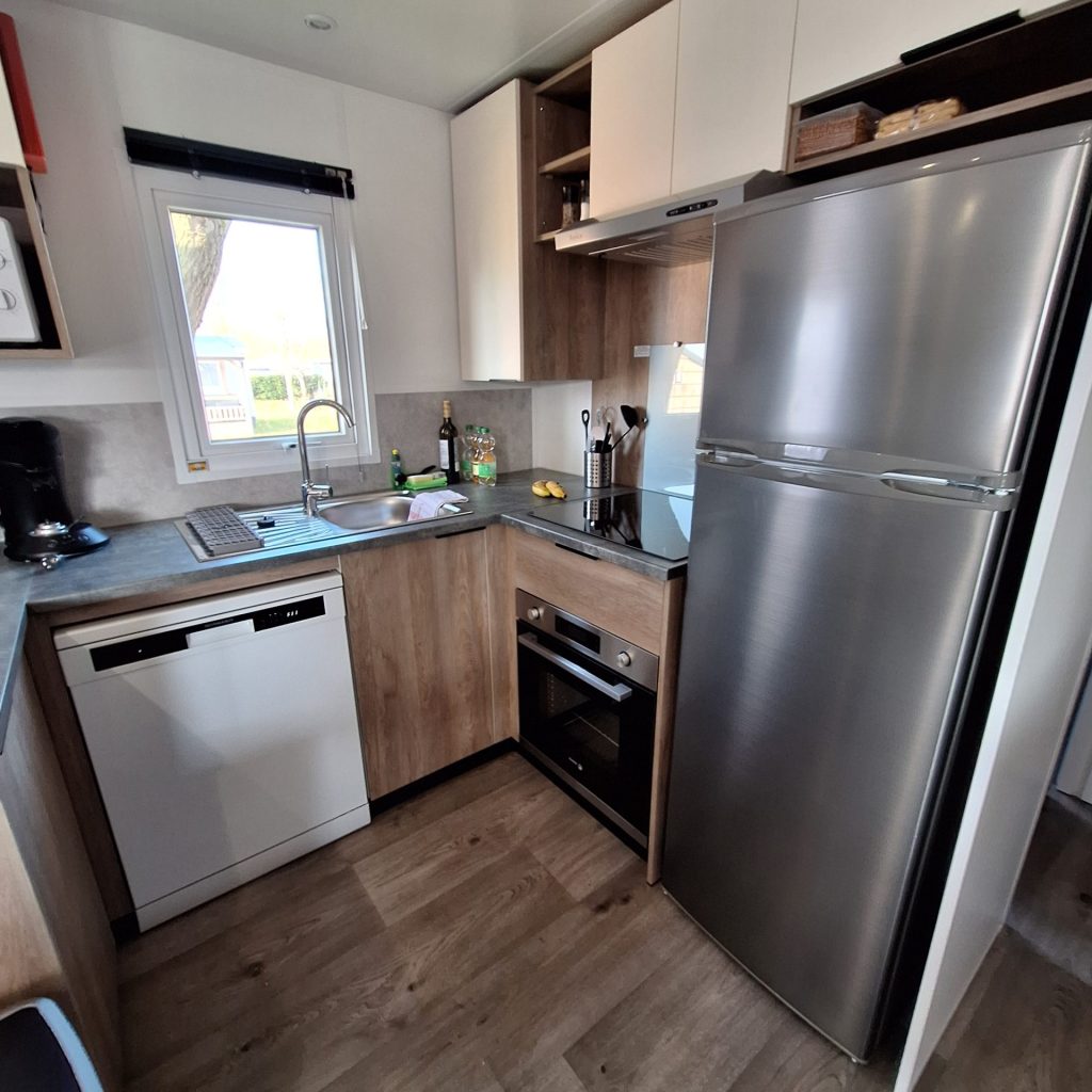 Eine Küche mit Kühlschrank, Herd und Spüle, die einen funktionalen Kochbereich darstellt.